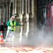 Seorang staf kebersihan membersihan grafiti di pintu Santo Basilica, Roma. Foto: dailymail.co.uk