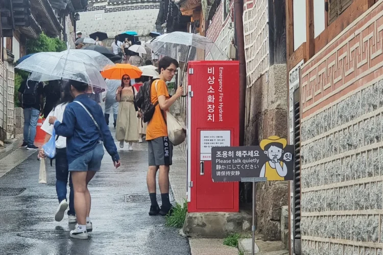 Wisatawan asing memenuhi jalan-jalan di Bukchon Hanok, sebuah desa kuno dengan rumah-rumah tradisional. Foto: Rhee Soo-young/CNN